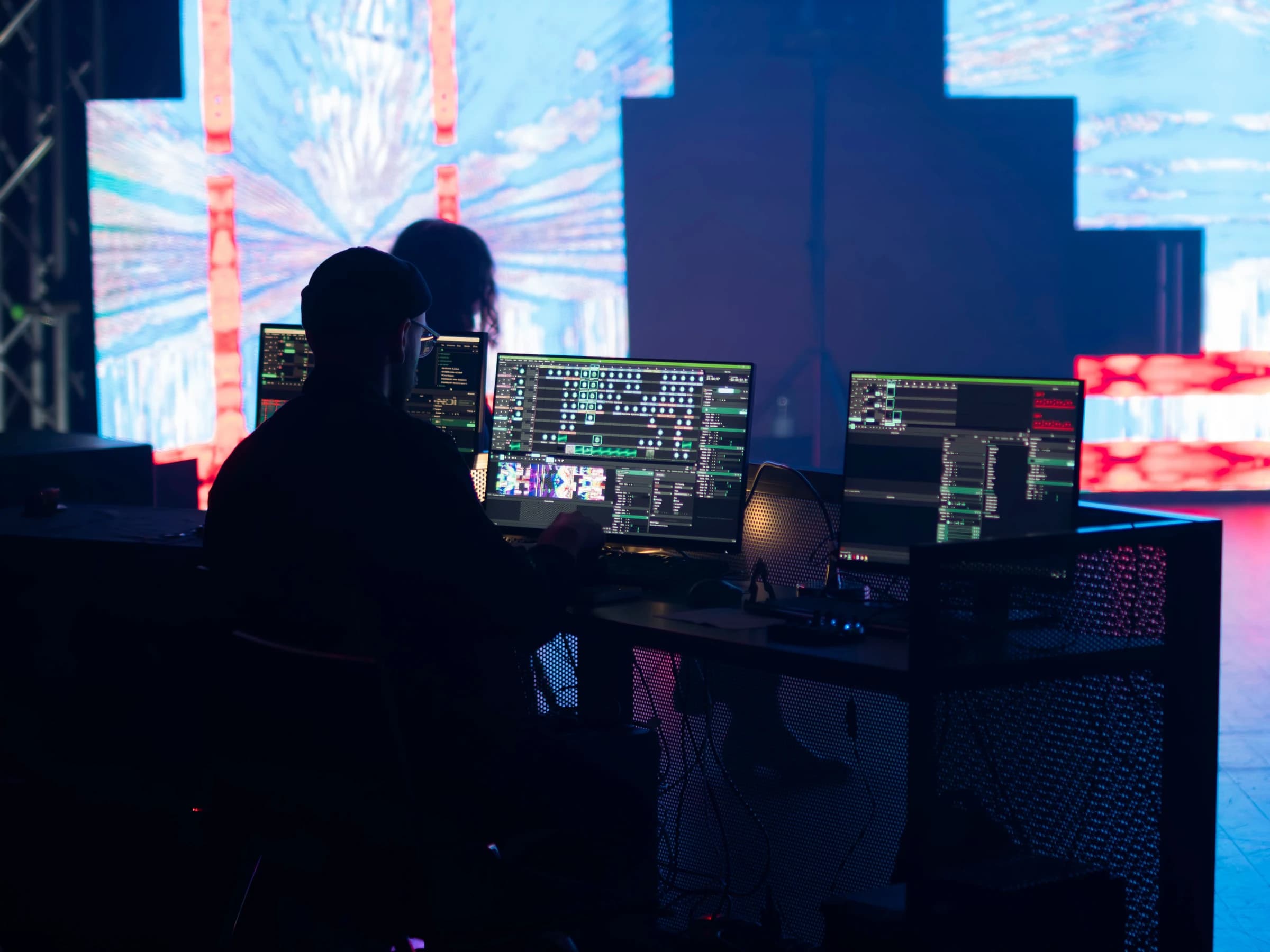 Technicien en régie devant un mur d'écrans LED pendant un événement